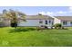 Grassy backyard featuring a patio, landscaped flower beds, and a privacy fence at 5893 Crosscut Ln, Noblesville, IN 46062