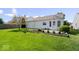 Backyard view showcasing green lawn, landscaping, and an outdoor patio area at 5893 Crosscut Ln, Noblesville, IN 46062