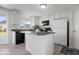 Well-lit kitchen features an island, white cabinetry, and black appliances at 5893 Crosscut Ln, Noblesville, IN 46062
