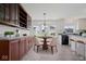 Open kitchen/dining area with wood cabinets, table with seating, and lots of natural light at 5893 Crosscut Ln, Noblesville, IN 46062