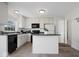 Well-lit kitchen features an island, white cabinetry, and black appliances at 5893 Crosscut Ln, Noblesville, IN 46062