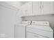 Efficient laundry room with a washer, dryer, storage cabinets, and shelving at 5893 Crosscut Ln, Noblesville, IN 46062