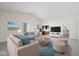 Stylishly furnished living room with neutral tones, plush seating, and a seamless connection to the kitchen at 5893 Crosscut Ln, Noblesville, IN 46062