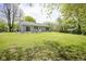 A lush, green backyard with a well-maintained lawn and a charming single-story home with sliding glass doors at 5938 Dunseth Ct, Indianapolis, IN 46254