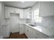Updated kitchen features white cabinets, subway tile backsplash, granite countertops, and a stainless steel sink at 5938 Dunseth Ct, Indianapolis, IN 46254