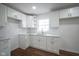 Bright kitchen with white cabinets, subway tile backsplash, granite countertops, stainless steel sink, and hardwood flooring at 5938 Dunseth Ct, Indianapolis, IN 46254