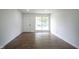 Well-lit living room featuring new hardwood floors, fresh white walls, and a large window allowing ample natural light at 5938 Dunseth Ct, Indianapolis, IN 46254