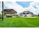 A picturesque backyard features a putting green, luxurious outdoor kitchen and grill, and beautifully landscaped areas at 5990 Hollow Ct, Bargersville, IN 46106