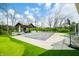 Beautiful backyard with a pool and outdoor kitchen area, surrounded by lush green lawn and mature trees at 5990 Hollow Ct, Bargersville, IN 46106