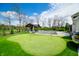 Expansive backyard with a putting green, covered outdoor kitchen, and a pool, perfect for entertaining and leisure at 5990 Hollow Ct, Bargersville, IN 46106