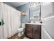 Bathroom featuring blue walls, a vanity with dark wood cabinets, a toilet, and a shower/tub with white curtain at 5990 Hollow Ct, Bargersville, IN 46106