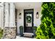 Close up of the front door, with a wreath, potted plants and outdoor lantern sconces at 5990 Hollow Ct, Bargersville, IN 46106