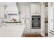 Bright kitchen features white cabinets, stainless steel appliances and large island at 5990 Hollow Ct, Bargersville, IN 46106