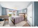 Main bedroom with blue walls featuring neutral decor, a large window, and carpeted floors at 5990 Hollow Ct, Bargersville, IN 46106
