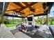 Spectacular outdoor kitchen includes a cozy seating area, fireplace, and grill, overlooking the landscaped yard and pond at 5990 Hollow Ct, Bargersville, IN 46106