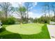 Lush putting green with picturesque pond views, surrounded by mature trees and landscaping, creating a serene setting at 5990 Hollow Ct, Bargersville, IN 46106