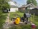 A view of the backyard with grass, lawnmowers, and other items laying in the yard at 616 N Exeter Ave, Indianapolis, IN 46222
