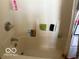 Bathtub featuring wall-mounted faucet, and plastic shelving for toiletries at 616 N Exeter Ave, Indianapolis, IN 46222