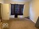 This bedroom features carpeted floors, and a window with dark curtains at 616 N Exeter Ave, Indianapolis, IN 46222