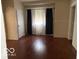 Bedroom area showing the hardwood floors, a window with curtains, and doorways on either side at 616 N Exeter Ave, Indianapolis, IN 46222