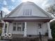 Traditional home featuring a quaint porch with decorative columns, windows, and fresh exterior paint at 616 N Exeter Ave, Indianapolis, IN 46222