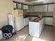 The kitchen has white cabinets and appliances, a tile floor, and overhead lighting at 616 N Exeter Ave, Indianapolis, IN 46222