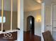 Open living room featuring a large archway, a light fixture on the painted wall, and hardwood floors at 616 N Exeter Ave, Indianapolis, IN 46222