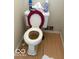 Toilet featuring a covered seat, next to wood flooring at 616 N Exeter Ave, Indianapolis, IN 46222