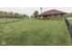Large backyard with green grass, a brick house, and a chainlink fence at 6494 N Baltimore Rd, Monrovia, IN 46157