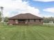 Spacious, flat backyard with a brick house, wood deck, and chainlink fence at 6494 N Baltimore Rd, Monrovia, IN 46157