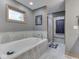 Bathroom with a soaking tub, tiled walls, and neutral decor at 6494 N Baltimore Rd, Monrovia, IN 46157