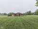 Sprawling brick home on a large lot featuring manicured lawns and mature trees at 6494 N Baltimore Rd, Monrovia, IN 46157