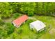 Aerial view of home with red roof and a detached garage surrounded by lush greenery at 680 Unity Church Rd, Morgantown, IN 46160