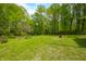Spacious backyard with lush green grass surrounded by many trees at 680 Unity Church Rd, Morgantown, IN 46160