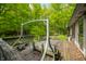 Wooden deck with swing seat overlooking a lush green landscape with mature trees at 680 Unity Church Rd, Morgantown, IN 46160