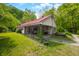 Charming home with a red roof, covered carport and green lawn surrounded by mature trees at 680 Unity Church Rd, Morgantown, IN 46160