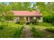 Charming single-story home with a red metal roof, stone path and a well-kept lawn at 680 Unity Church Rd, Morgantown, IN 46160