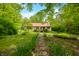 Charming home with a red roof and pathway leading to the front door, surrounded by trees at 680 Unity Church Rd, Morgantown, IN 46160