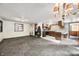 Open-concept living room and kitchen with neutral carpeting, vintage wood cabinets and white appliances at 680 Unity Church Rd, Morgantown, IN 46160