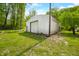 Exterior of the property's large storage outbuilding with roll up door on a verdant lot at 680 Unity Church Rd, Morgantown, IN 46160