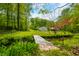 Spacious yard with a bridge over a creek leading to a red-roofed home and white garage at 680 Unity Church Rd, Morgantown, IN 46160