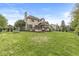 Expansive backyard with a deck, screened in porch, and mature trees offering a private outdoor space at 6818 Bluffridge Dr, Indianapolis, IN 46278