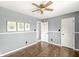 Bedroom with light gray walls, wood floors, ceiling fan, and white trim at 6818 Bluffridge Dr, Indianapolis, IN 46278