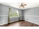Bedroom with light gray walls, wood floors, and large window covered with curtains at 6818 Bluffridge Dr, Indianapolis, IN 46278