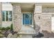 Inviting front entrance with brick columns, blue door, and landscaped garden beds at 6818 Bluffridge Dr, Indianapolis, IN 46278