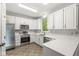 Bright kitchen with white cabinets, stainless steel appliances, and stone countertops at 6818 Bluffridge Dr, Indianapolis, IN 46278