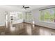 Open-concept living room with hardwood floors, large windows, and view to kitchen at 6818 Bluffridge Dr, Indianapolis, IN 46278