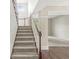 Carpeted staircase with wooden railing leading to a bright and open living space at 6818 Bluffridge Dr, Indianapolis, IN 46278