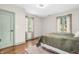 Bedroom featuring two windows, hardwood flooring, and light green trim and door at 695 W Clinton St, Danville, IN 46122