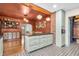 Open concept kitchen with light green island, mosaic tile flooring, and a brick accent wall at 695 W Clinton St, Danville, IN 46122